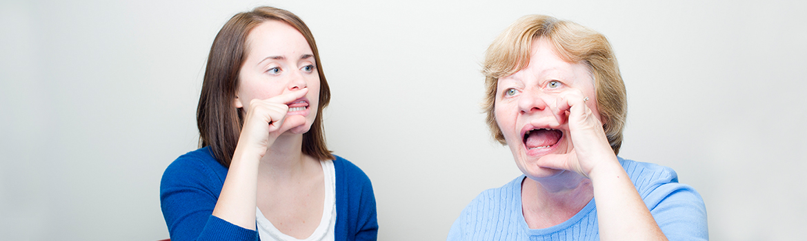 Two people touching their mouth