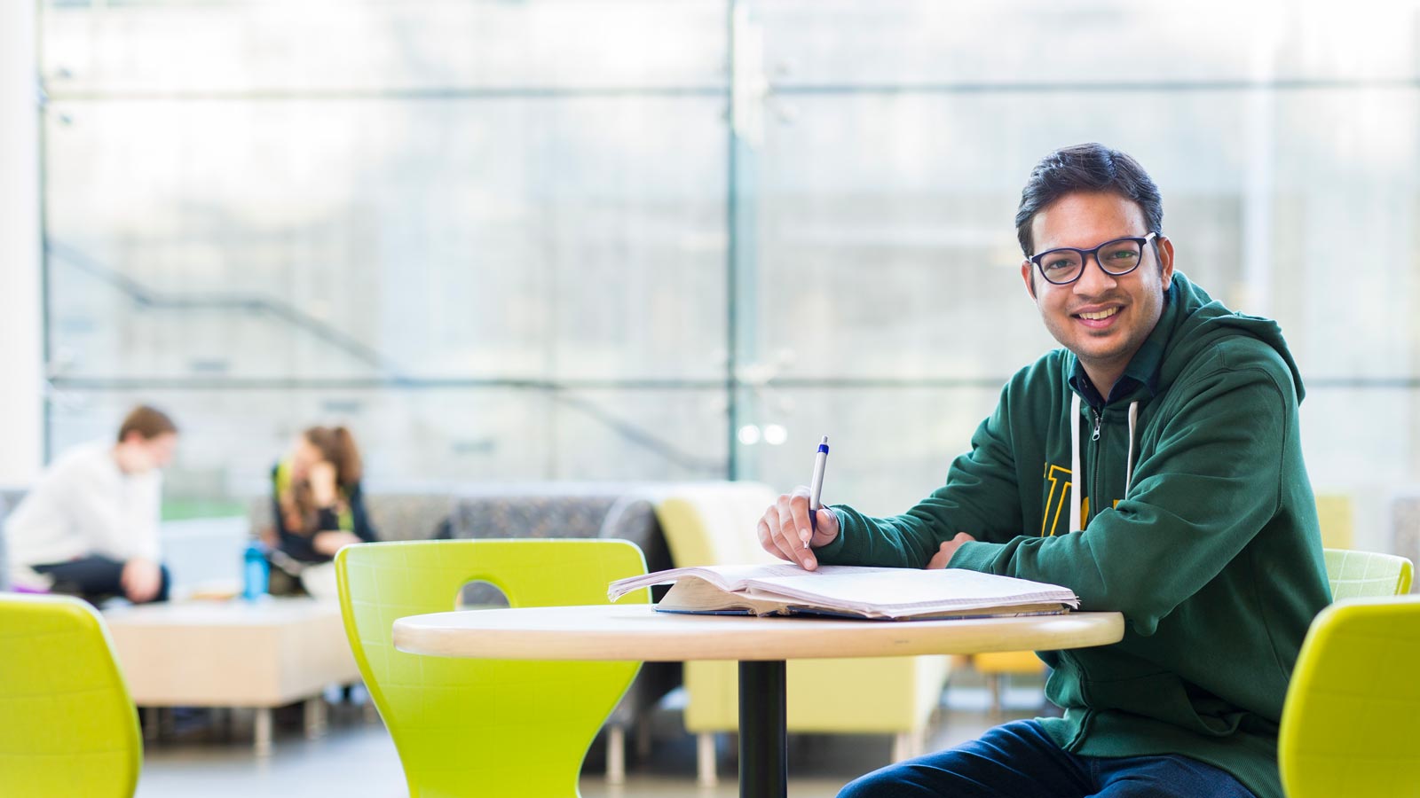student in green U of A hoody smiling